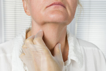 Doctor exames the thyroid gland in a patient of an adult woman, thyroid cancer
