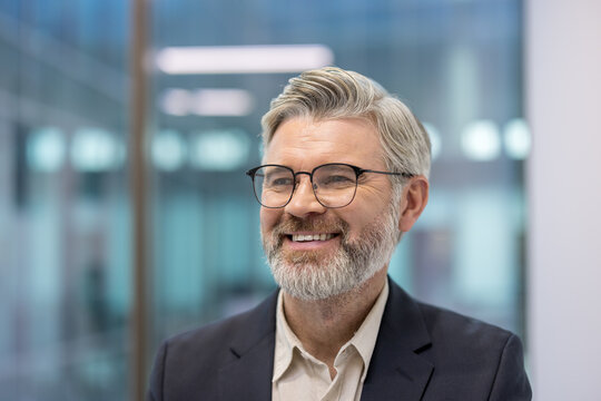 Smiling professional man with glasses in a modern office environment