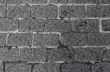 Texture of gray square paving tile. Pattern of sidewalk tiles in the street. Concrete pavers close up background.	