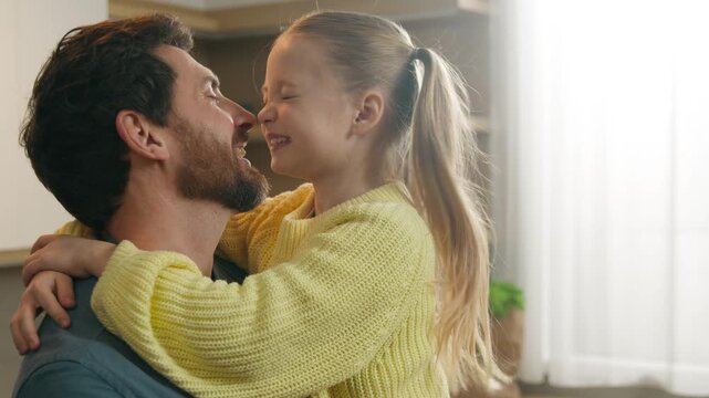 Loving 10s daughter spend weekend with caring daddy cuddling custody Caucasian happy family at home kitchen touch noses enjoy priceless carefree time together father with kid child girl hug close up