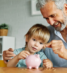 Grandparent And His Grandson Putting Coin Money In Piggybank  At Home. Personal Savings, Bank...
