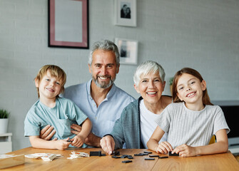 Portrait of happy grandparents and grandchildren sitting and posing together at home