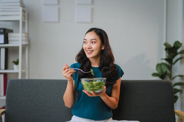 Young woman enjoying a healthy salad at home