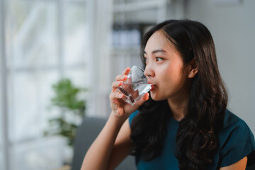 Office worker drinking water from a glass in the office