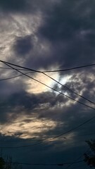 Dramatic sky with dark clouds and power lines creating a moody atmosphere