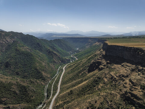Aerial view of the stark contrast between the rugged terrain and the snaking road that cuts through the gorge, Lori, Lori Province, Armenia.