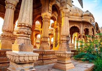 The royal cenotaphs of historic rulers, also known as Jaisalmer Chhatris, at Bada Bagh in Jaisalmer, Rajasthan, India. Cenotaphs made of yellow sandstone at sunset