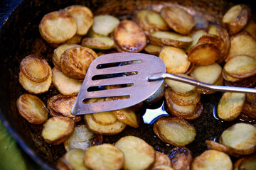 Baked in the oven potatoes with spices in a pan on a wooden table. The concept of delicious and healthy home-cooked food. Rustic style. Organic vegetables
