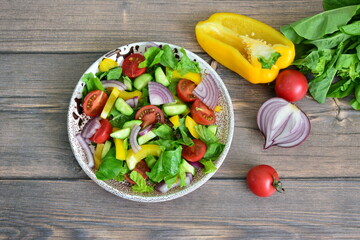 Colorful Salad with Fresh tomato, cucumber, red onion and yellow bell pepper on a Plate