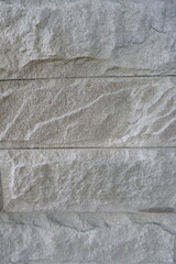 Textured grey rock wall background with natural rugged surface evokes powerful and earthy feeling. Ideal for design elements requiring