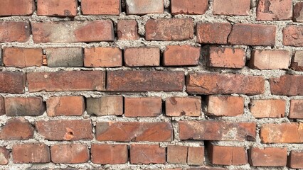 Obraz premium weathered red brick wall with irregular alignment and rough mortar texture