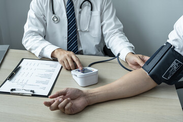 The doctor is checking blood pressure and is also using a stethoscope, to check for the cause of the patient's illness and to advice health care at hospital office