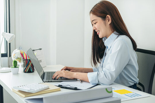 Woman office worker typing business project report on laptop and work hard to thinking of new idea for business