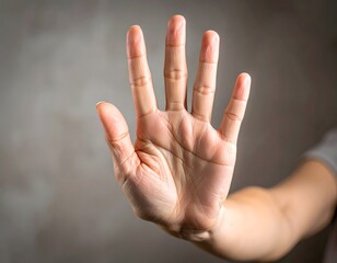 A person's hand raised with an open palm in a universal stop gesture, symbolizing refusal, setting boundaries, and saying no