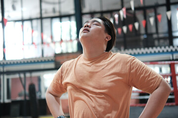Fitness and determination. A plus-size Asian man resting during his training.