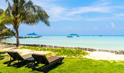 Amazing view of beautiful beach with palm trees, chaises and transparent turquoise water. A great place to relax. Ko Phi Phi Don island, Krabi province, Thailand, Andaman Sea. Artistic picture. 