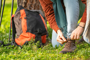 Close up of hiker man tying shoelaces on hiking boots, getting ready for outdoor adventure