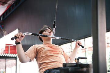 Overweight Man Doing Lat Pulldown Exercise at Gym. Upper Body Strength Training