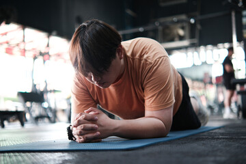 Overweight Man Doing Plank Exercise on Mat at Gym. Core Strength and Endurance Training