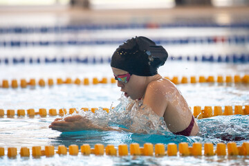Swimmer girl swims breaststroke swimming style in the pool