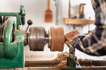 Carpentry. Turnery of a wooden bowl with spiral sawdust shavings with hand and chisel. High quality photography