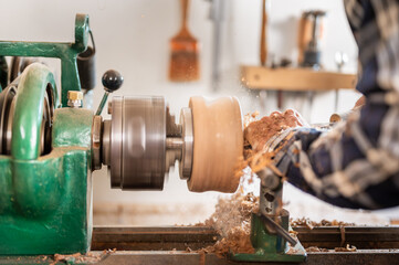 Carpentry. Turnery of a wooden bowl with spiral sawdust shavings with hand and chisel. High quality photography