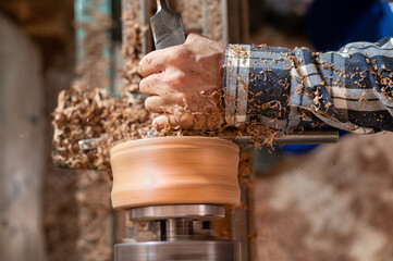Carpentry. Turnery of a wooden bowl with spiral sawdust shavings with hand and chisel. High quality photography
