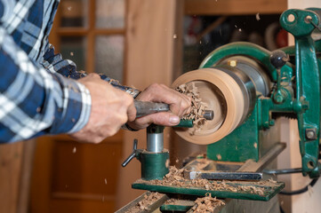 Carpentry. Turnery of a wooden bowl with spiral sawdust shavings with hand and chisel. High quality photography