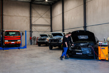air conditioner technician talking with customer about car in workshop