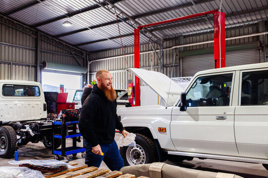 Happy smiling australian mechanic in industrial workshop shed