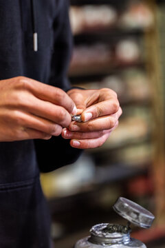 Mechanics hands holding small mechanical part beside workbench