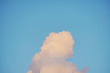 Soft Pink Cumulus Cloud Against Clear Blue Sky at Sunset