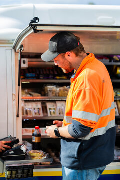 male worker on lunch break at industrial workplace purchasing snacks to eat