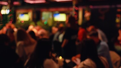 The blurred background highlights a lively bar scene with patrons interacting and enjoying themselves