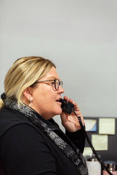Female front desk staff lady on telephone call inside office