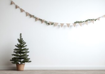 Minimalist Christmas decor on a white wall. A small, potted evergreen tree sits beside a burlap banner with greenery