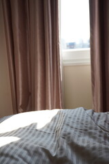 ベッドルームのカーテンの隙間から入る朝日（縦位置）