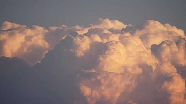 Left to right pan past glowing top of cumulonimbus cloud at sunset in Africa 