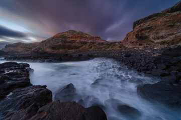 Coastal Inlet at Sunset with Storm Clouds