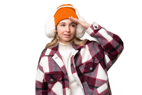 Young English woman wearing winter muffs over isolated background looking far away with hand to look something