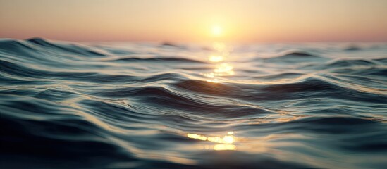 Close-up view of ocean waves at sunrise. Sunlight reflecting on rippling water