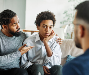 Father with his teenage son at meeting with social worker, psychologist discussing mental health...