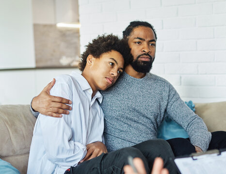 Father with his teenage son at meeting with social worker, psychologist discussing mental health family sitting on sofa in psychotherapist office