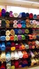 Colorful fabric rolls on shelves
