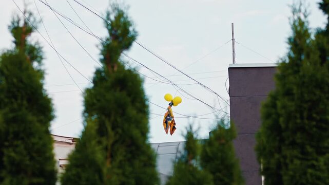 A Colorful Balloon Puppet Beautifully Caught on Power Lines in a Vibrant Urban Setting for All to See