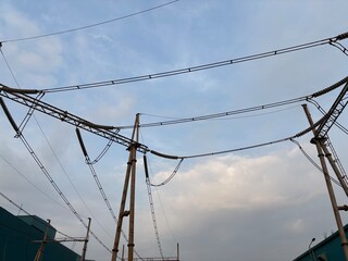 Fototapeta premium High voltage power lines stretching across a partly cloudy sky industrial infrastructure and electricity distribution network depicting modern energy transfer and technology with strong electrical