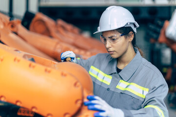 Engineer woman working in machine factory. Indian female engineer work in robot arm assembly plant