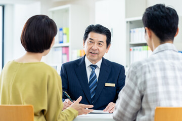 ミドルの夫婦に説明するプランナー