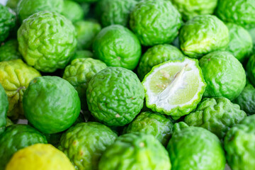 Fresh green kaffir limes displayed in a close-up view, showing vibrant color and unique bumpy texture, perfect for culinary, herbal, and natural ingredient concepts in food and beverage industry.