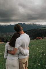 Naklejka premium Romantic Couple Embracing in Mountain Meadow
